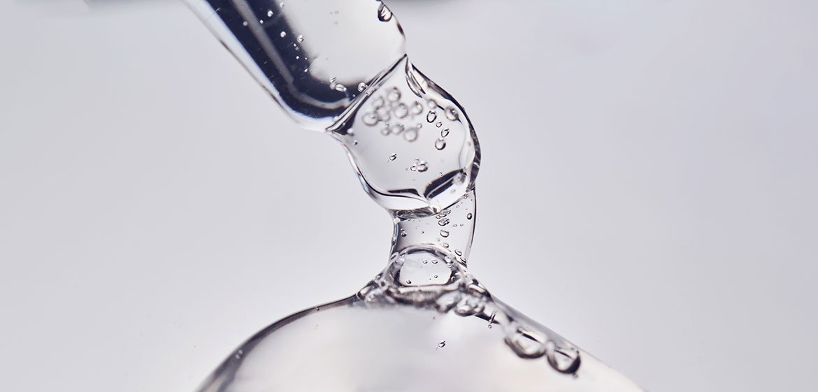 Hyaluronsäure-Serum: Nahaufnahme einer Pipette, aus der das Produkt tropft